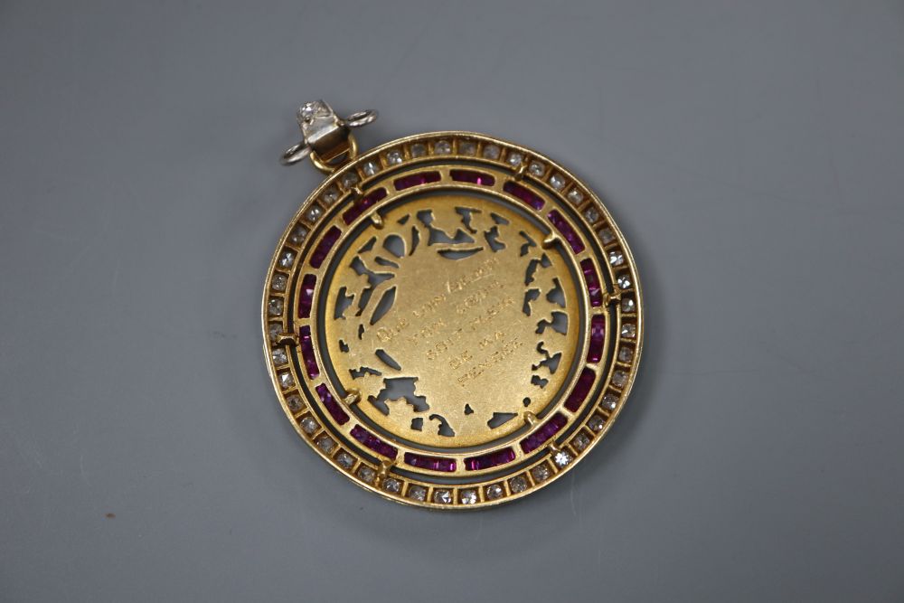 An early 20th century pierced yellow metal, ruby and diamond set circular pendant, 30mm gross 8.1 grams,